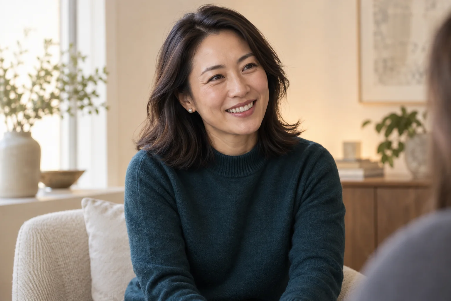 A woman smiling naturally during a conversation in soft daylight.