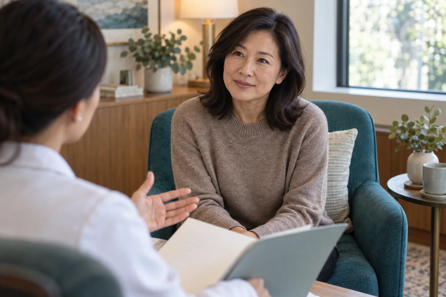 A woman listening during a discussion with a folder open on the table.