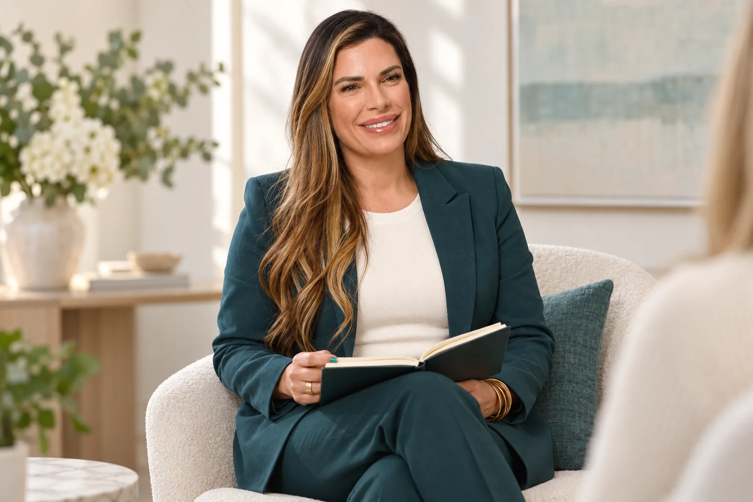 Eileen Rivera Jimenez seated with an open notebook in a warm neutral setting.