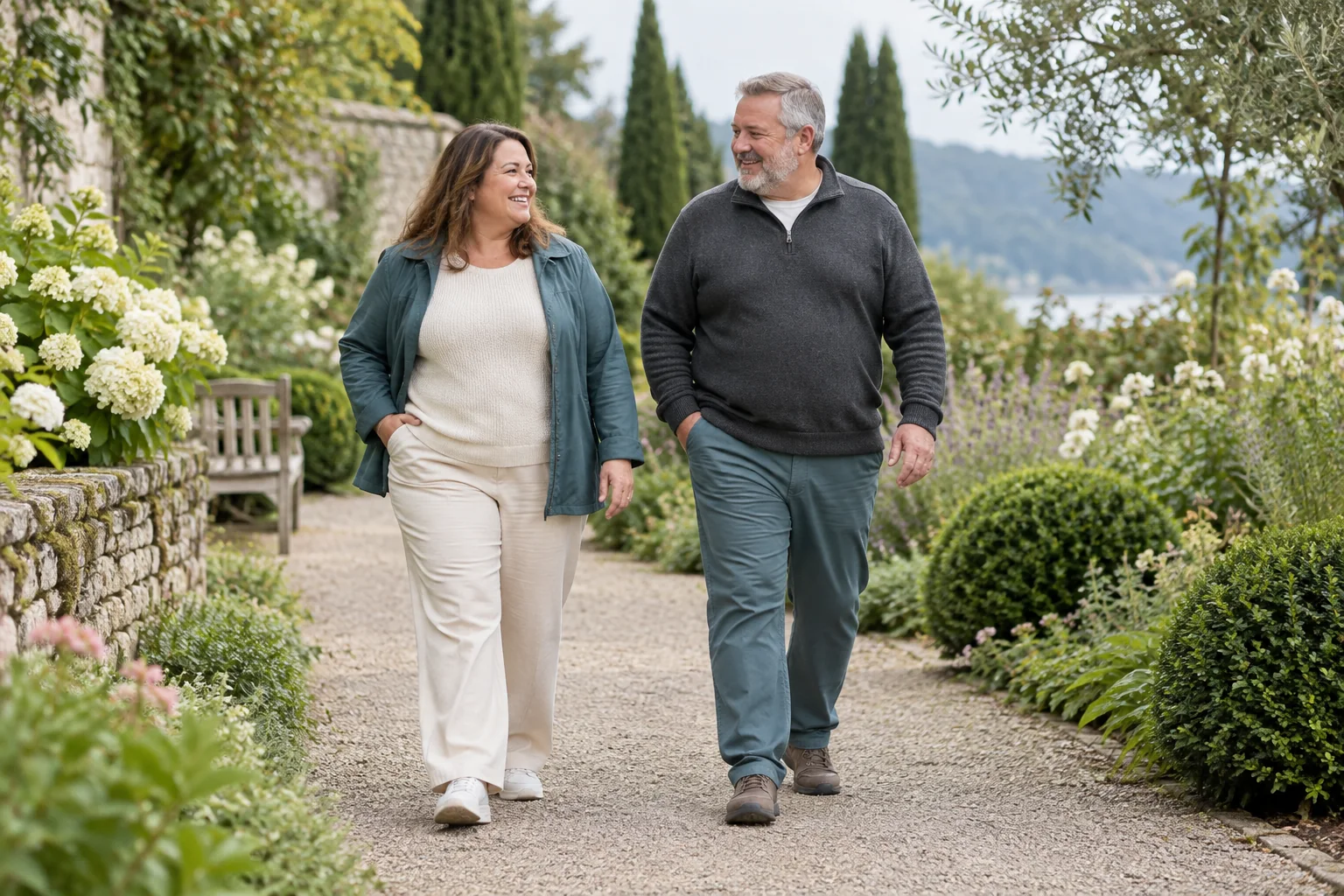 Two adults walking at an easy pace along a leafy garden path.