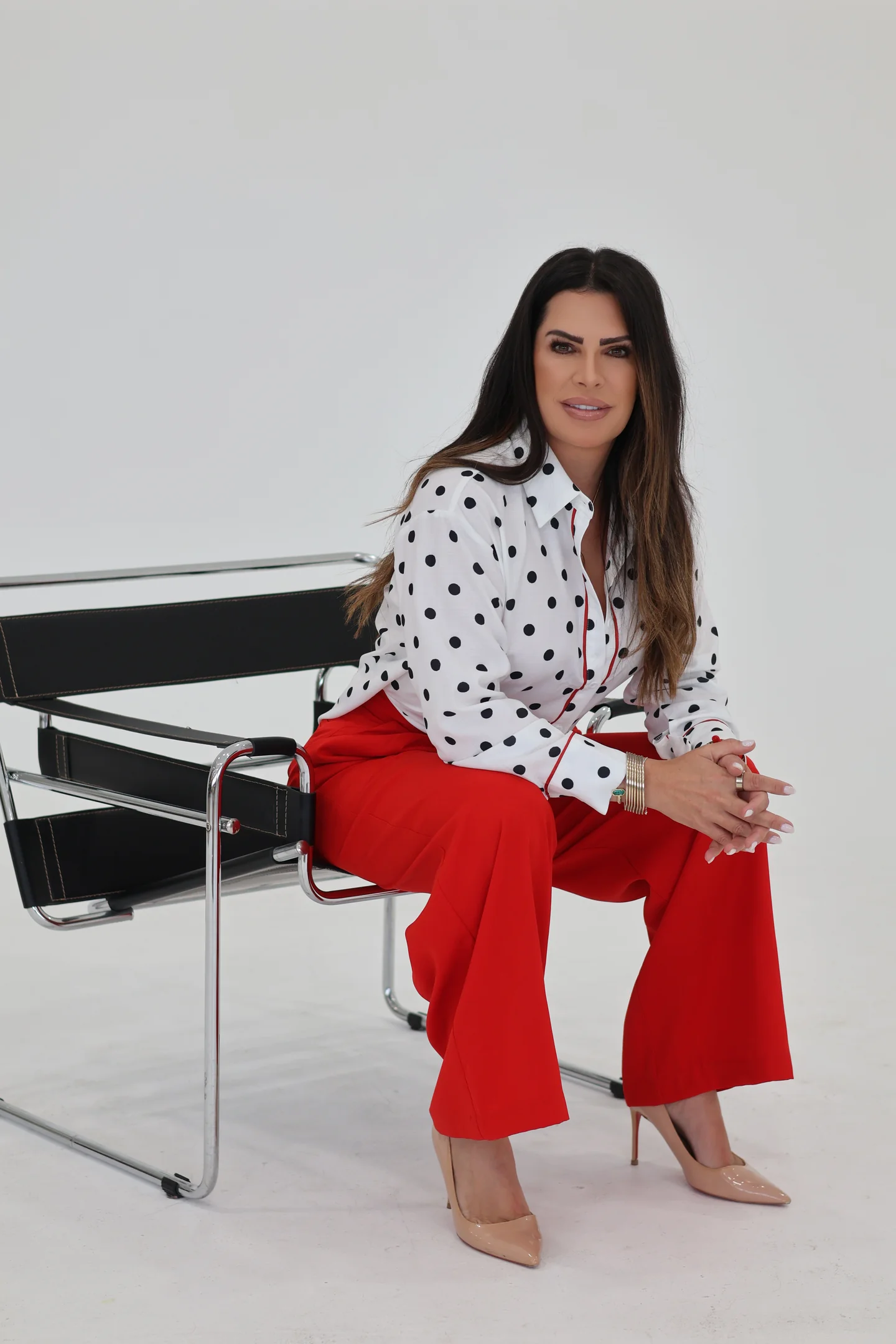 Dr. Eileen Rivera Jimenez, DNP, FNP, seated in a studio portrait with hands clasped.