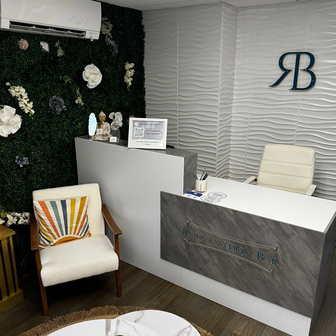 The Rejuvenation Bar North Providence reception desk with the branded sign and plant wall.